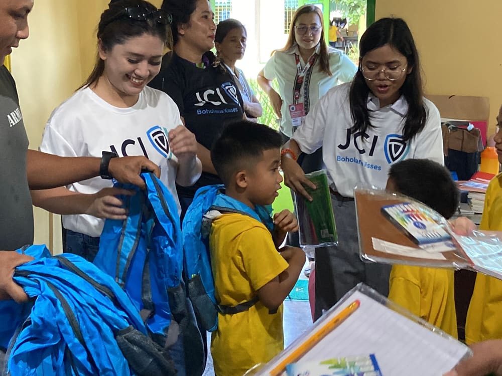 Members distributing school bags to students