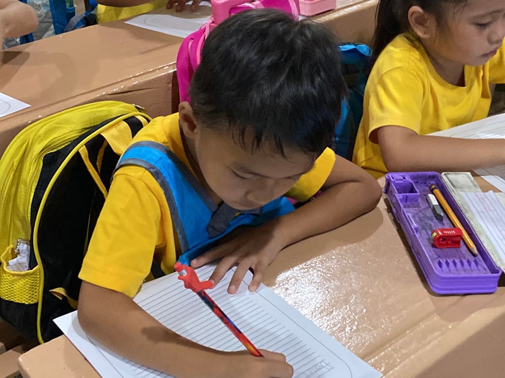 A young student writing during the program