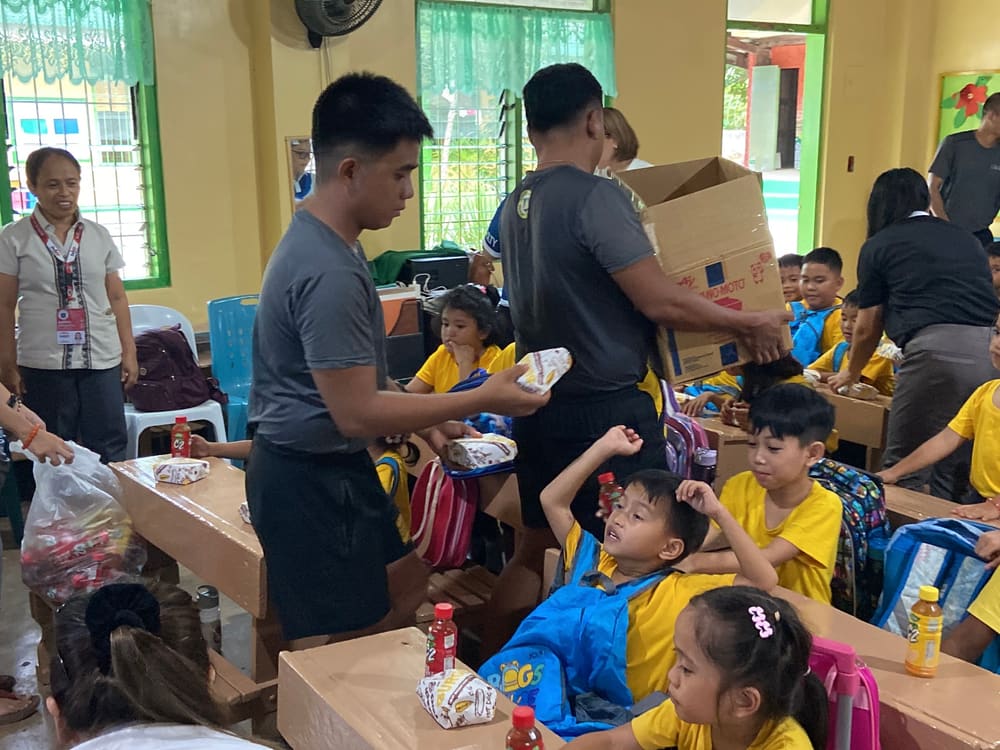 Handing a school bag to a student