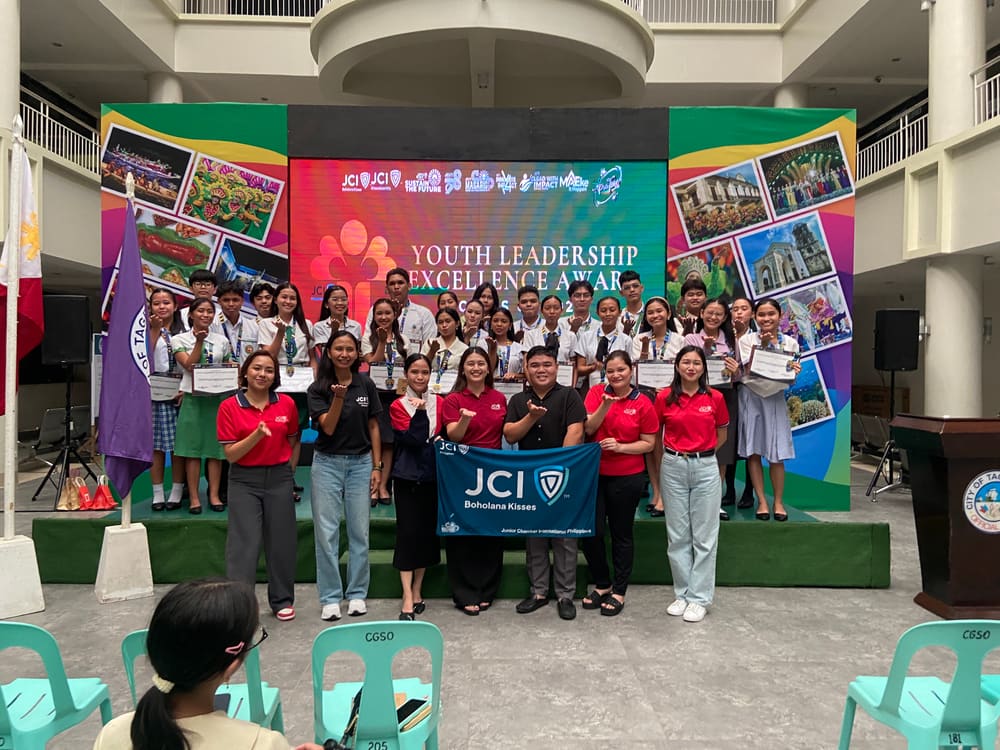 YLEA awardees on stage with the JCI Boholana Kisses flag
